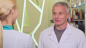快乐的高级男性化学家和他在药店的同事交谈8秒视频