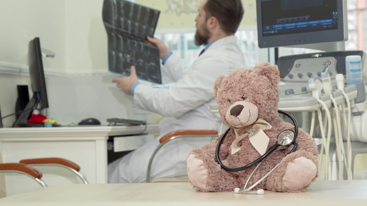 雄性小儿科医生检查在前台表面的有菌扫描和肥玩具泰迪熊视频