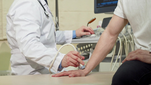 医生用超声波扫描仪检查男子的手腕骨骼14秒视频
