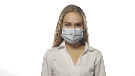 身戴医疗面具的金发护士在白色背景上直视摄像头有救护视频
