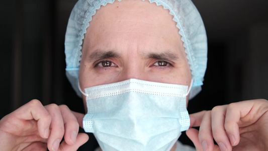 大流行期间戴着防护面具的男医生一位疲惫的医生的特写视频