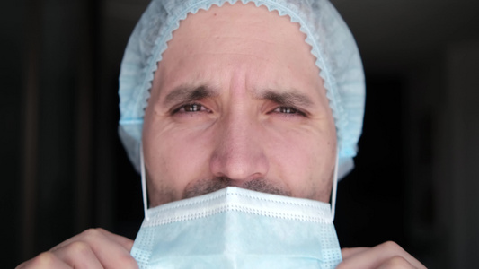 大流行期间戴着防护面具的男医生一位疲惫的医生的特写视频