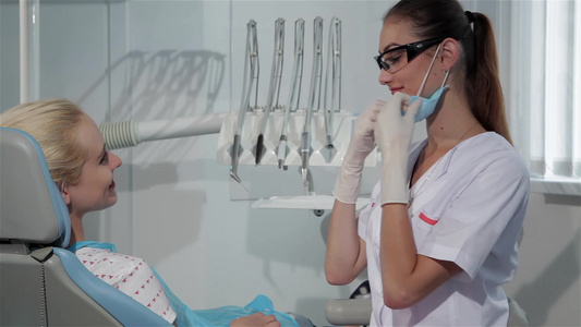 女牙医开始在牙医内阁对她的病人进行检查a女性牙医视频