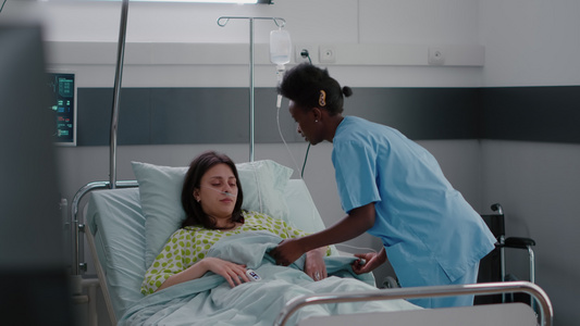 美国护士帮助病人舒适地坐在医院病房中帮助病人安居乐业视频