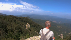 坐在位于西班牙河边山顶的岩石上观赏西班牙山峰的壮观15秒视频