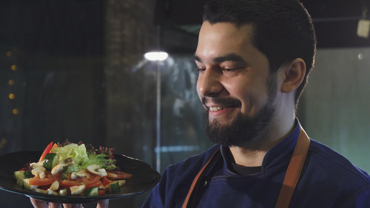 英俊的男厨师笑着拿着沙拉的盘子视频