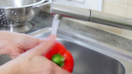 洗胡椒在水槽中的妇女视频