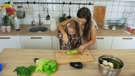 妈妈和女儿在厨房做菜煮蔬菜视频