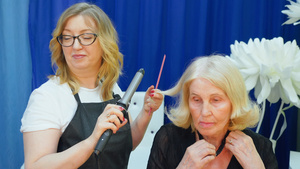 美容工作室年长妇女头发卷卷发的发型设计师23秒视频