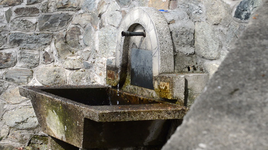 从金属管喷泉水池从侧面流出的清澈的冷水视频