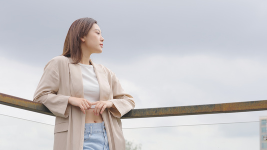 女人情绪低落靠着栏杆视频