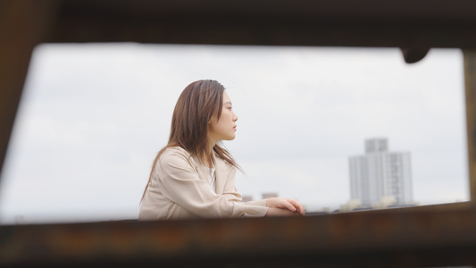 女人情绪低落靠着栏杆视频