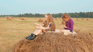 坐在干草堆上玩野外游戏的可爱女孩12秒视频