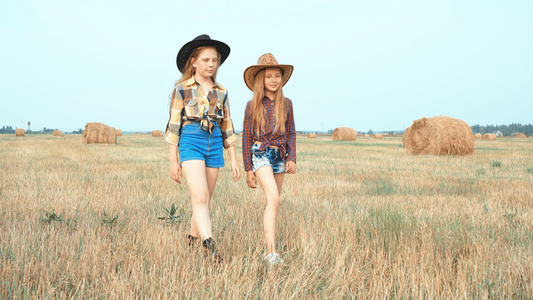 穿着帽子的可爱女孩带着干草堆在田里散步视频