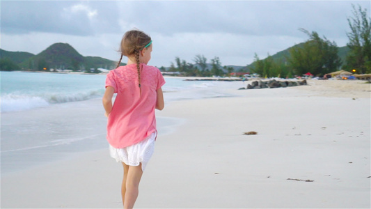 海滩上可爱的小女孩在卡比巴岛玩得开心慢动作视频