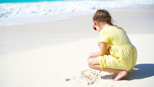 热带沙滩造沙城堡的可爱小可爱女孩视频