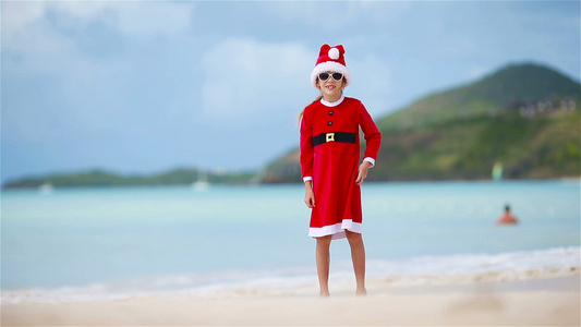 圣诞假期间在白沙滩上穿着圣诞帽的可爱女孩视频