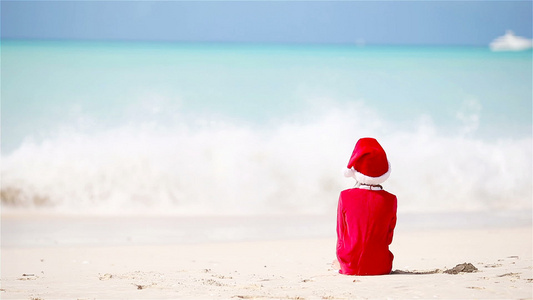 圣诞假期间在白沙滩上穿着圣诞帽的可爱女孩视频