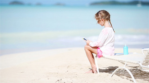 小女孩在白沙滩上晒着阳光享受18秒视频