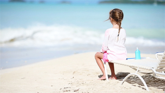小女孩在白沙滩上晒着阳光享受视频