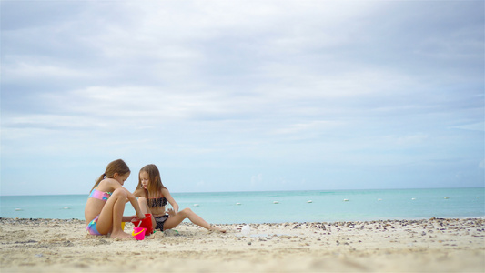 两个孩子在热带沙滩上造沙城堡和玩耍视频