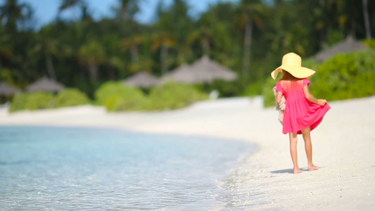 暑假期间海滩上可爱的小可爱女孩在沙滩上渡暑假视频