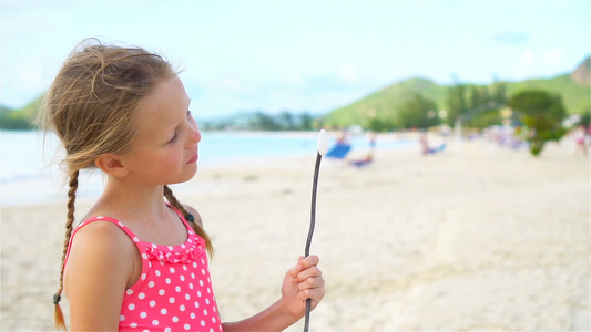 沙滩上可爱的小女孩玩得很开心慢动作视频