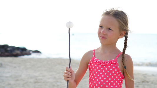 沙滩上可爱的小女孩玩得很开心慢动作视频