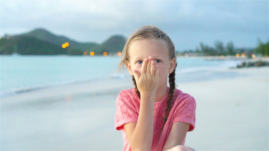 可爱的小女孩在海滩有很多在日落时的乐趣快乐的孩子看着视频