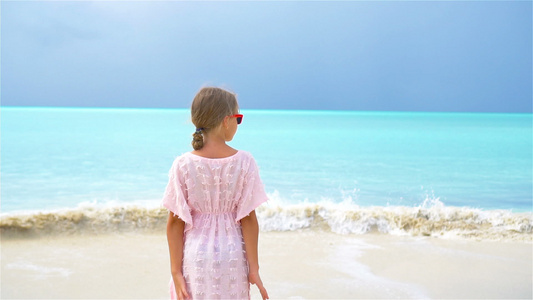 可爱的小女孩度假时在热带沙滩玩得开心慢动作视频