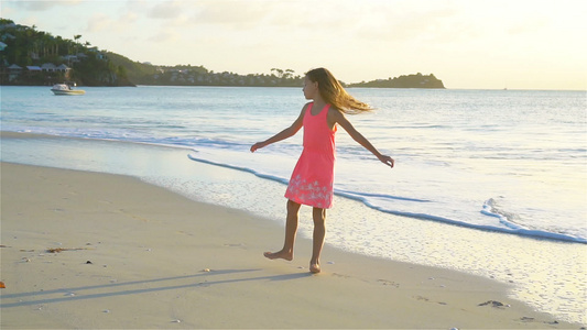 的小女孩度假时在热带沙滩玩得开心慢动作视频