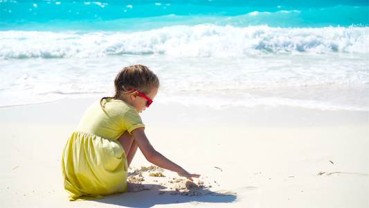 可爱的小女孩在白沙滩上玩沙子快乐的孩子享受海边度假视频