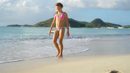 可爱的小女孩在热带海滩玩得开心视频