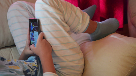 青少年在家用智能手机玩耍游戏视频