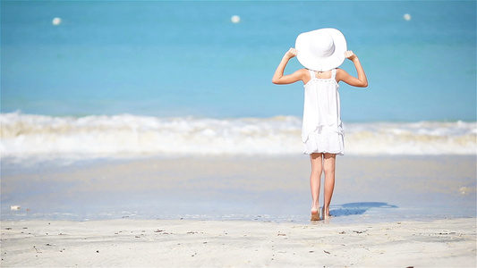 暑假期间海滩上可爱的小女孩在沙滩上渡假视频