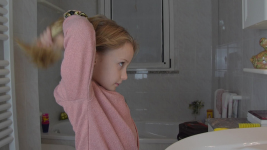 穿粉红色衬衫的金发小女生在家里浴室里视频