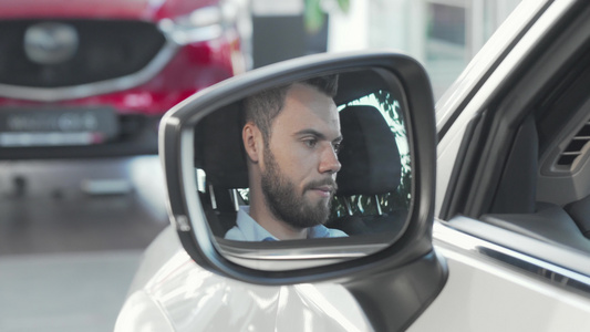 快乐的男子通过他的汽车侧镜展示了摄像头的车钥匙视频
