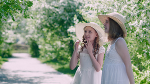 惊讶的女孩用手指向果园里开花的苹果树展示在春日阳光明媚21秒视频