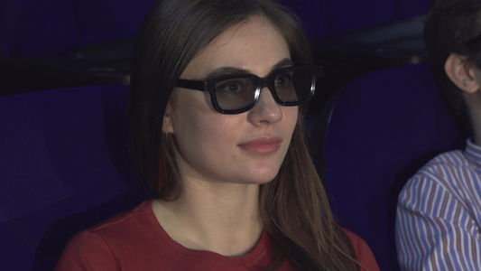 惊讶的女孩脱下3D眼镜更好地考虑电影的片刻视频