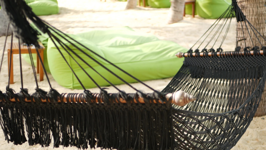 黑色的吊床在椰子树之间伸展网状复古时髦吊床边缘有边缘视频