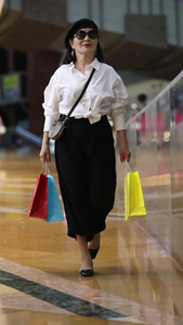 穿着潮流服饰的时尚女人走在购物中心视频