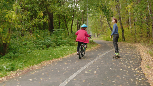 儿童在公园骑自行车和滑板后视线视频