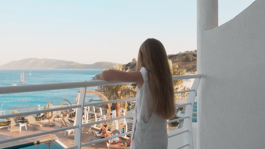 女孩站在阳台上看海景视频