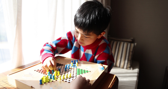 中国小孩在窗边下棋跳跳棋视频