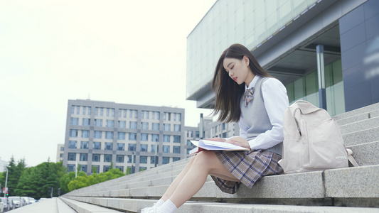 大学女生坐在台阶上看书视频