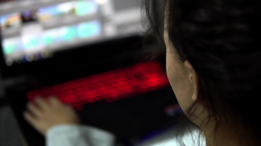 一位坐在咖啡馆用电动键盘在电脑上工作的有吸引力的妇女视频