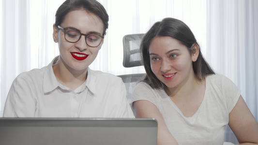 两名女性自由职业者在合作时使用笔记本电脑视频