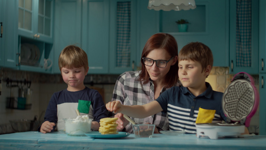 帮助两个孩子把奶油和巧克力加在自制华夫饼上孩子们喜欢视频