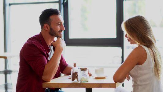相爱的年轻情侣坐在咖啡厅喝咖啡视频