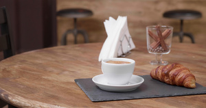一杯白咖啡在托盘上加一份羊角面包纸巾和一杯肉桂9秒视频